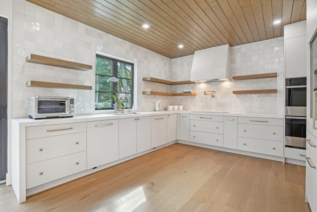 kitchen featuring wooden ceiling, sink, light wood-type flooring, custom exhaust hood, and white cabinets