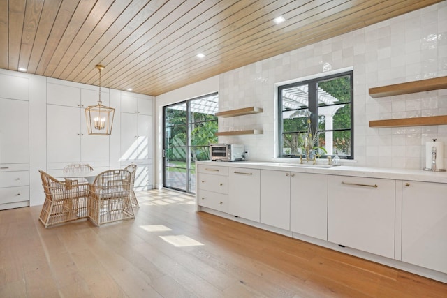 kitchen featuring wood ceiling, white cabinets, decorative backsplash, light hardwood / wood-style floors, and decorative light fixtures