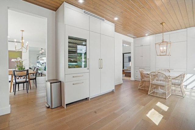 kitchen with white cabinets, decorative light fixtures, wooden ceiling, and light wood-type flooring