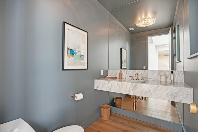 bathroom featuring sink, hardwood / wood-style flooring, and toilet