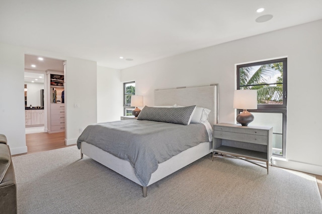 bedroom with hardwood / wood-style flooring and connected bathroom