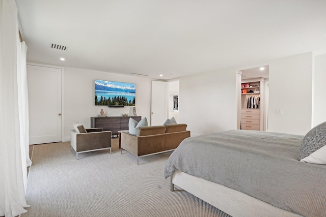 carpeted bedroom featuring a walk in closet and a closet