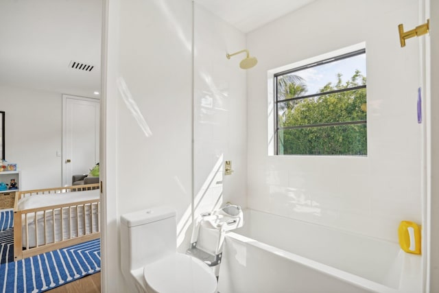 bathroom with toilet, hardwood / wood-style flooring, and tub / shower combination