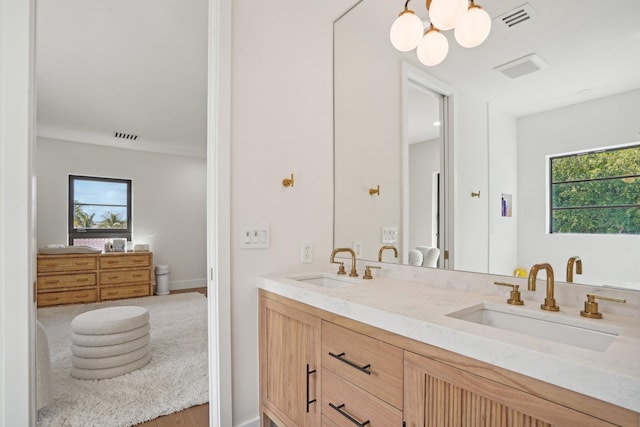 bathroom featuring vanity, an inviting chandelier, and hardwood / wood-style floors