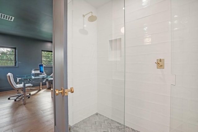 bathroom with hardwood / wood-style floors and tiled shower