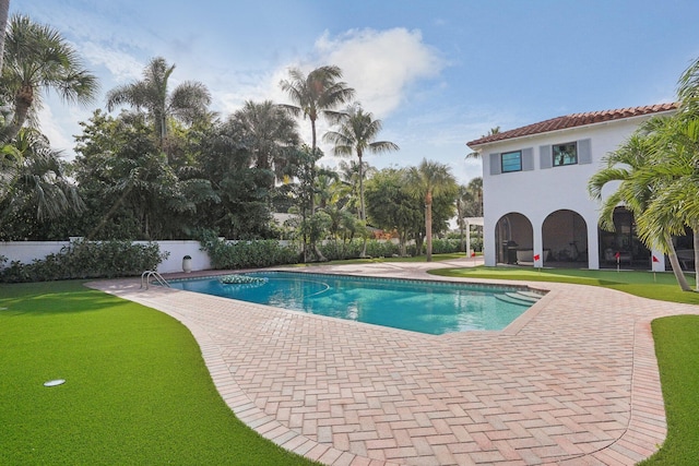 view of swimming pool featuring a patio area and a lawn