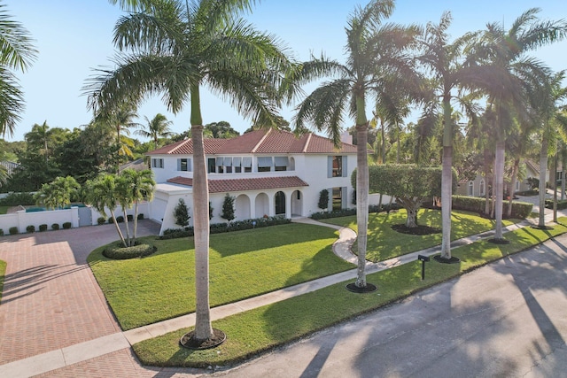 mediterranean / spanish-style home featuring a front yard and a garage