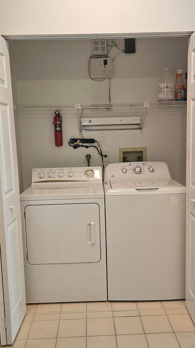 washroom featuring washing machine and dryer and light tile patterned floors