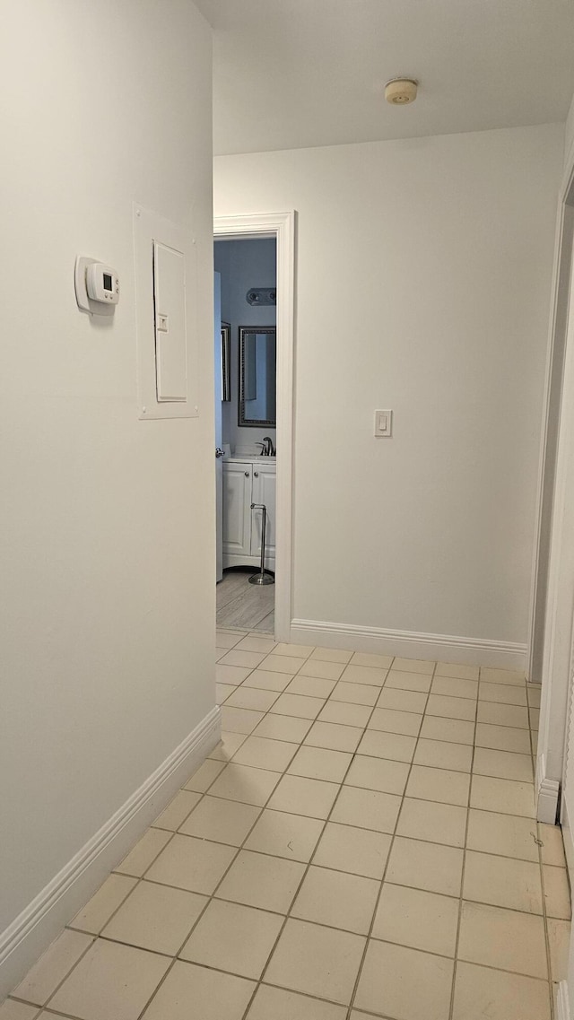 8637 Sunbird Pl, Boca Raton, FL 33496 - hall with electric panel, light tile patterned floors, baseboards, and a sink
