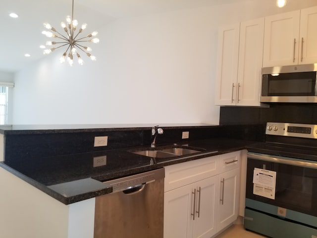 kitchen featuring an inviting chandelier, decorative light fixtures, sink, stainless steel appliances, and white cabinets