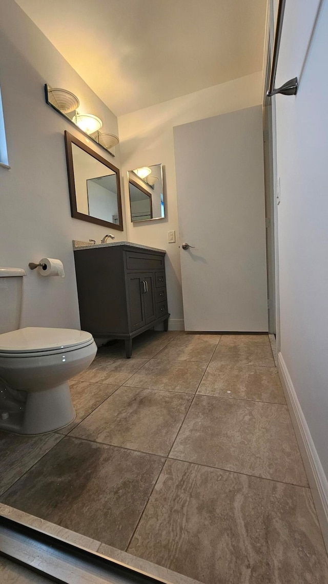 bathroom featuring concrete flooring, vanity, and toilet