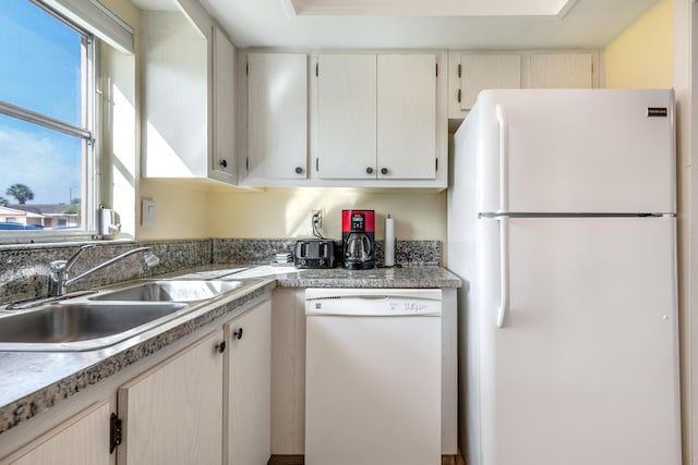 kitchen featuring white appliances and sink