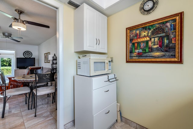 kitchen featuring white cabinetry and ceiling fan