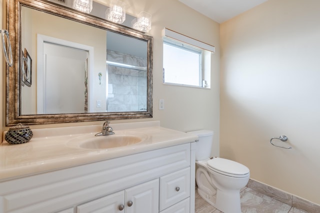 bathroom featuring vanity, toilet, and a shower with shower door