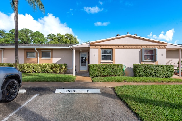 single story home featuring a front lawn