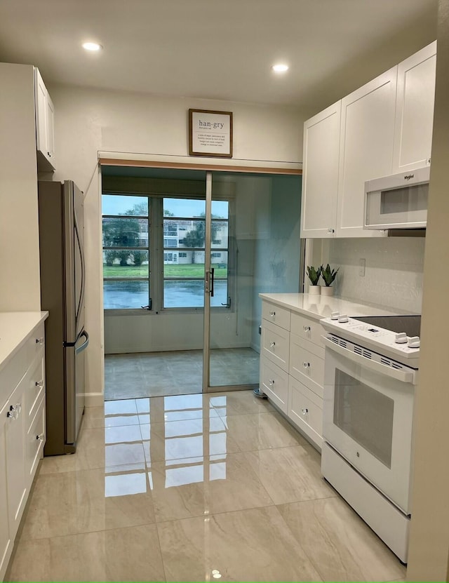 kitchen with white cabinetry and white appliances