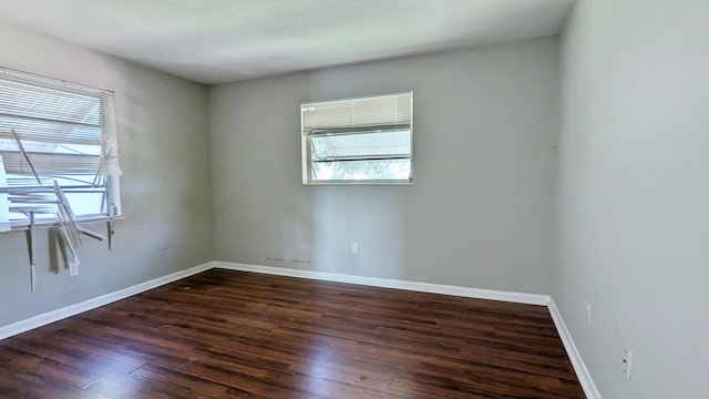 unfurnished room with a textured ceiling and dark hardwood / wood-style floors