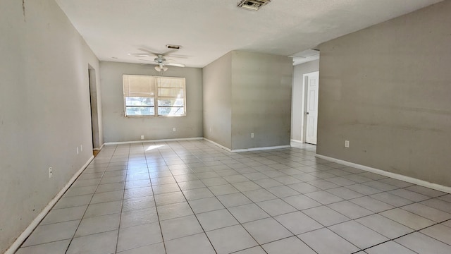 spare room with ceiling fan and light tile patterned flooring