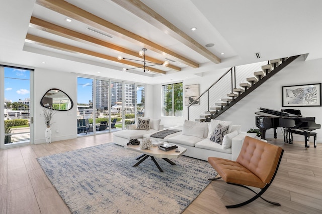 living room with beam ceiling, a chandelier, and light hardwood / wood-style flooring