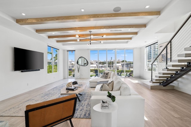 living room with light hardwood / wood-style floors, beamed ceiling, and a chandelier