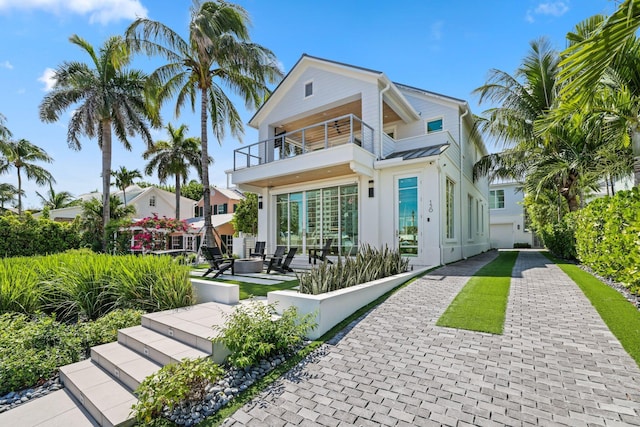 rear view of property featuring a balcony and a patio area