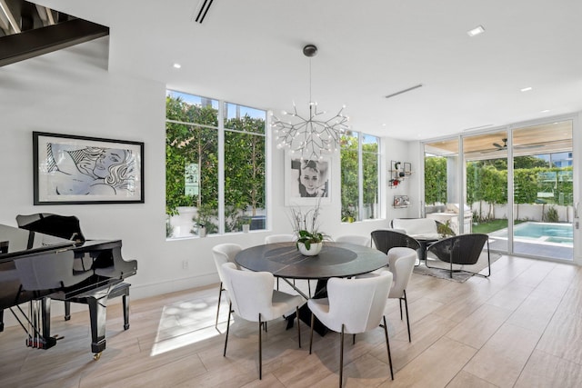 dining room featuring an inviting chandelier, light hardwood / wood-style floors, and floor to ceiling windows