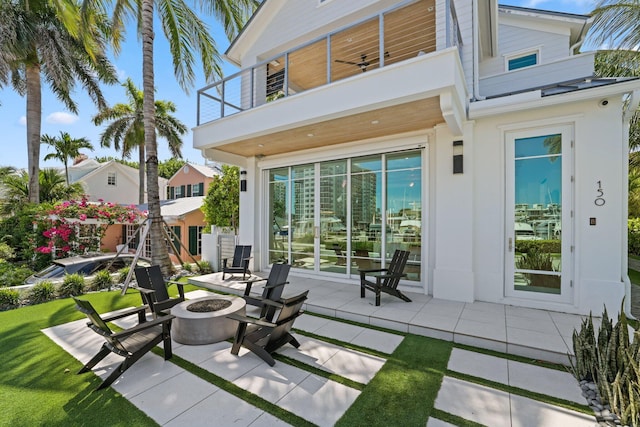 back of house featuring a patio area, a fire pit, ceiling fan, and a balcony