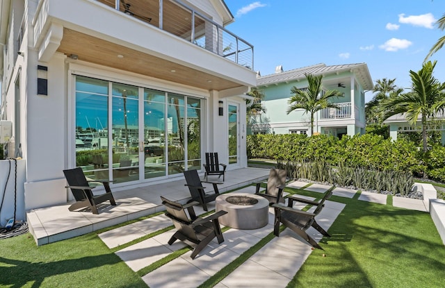 view of patio / terrace with a fire pit and a balcony