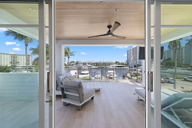 view of patio featuring a water view, ceiling fan, a balcony, and outdoor lounge area