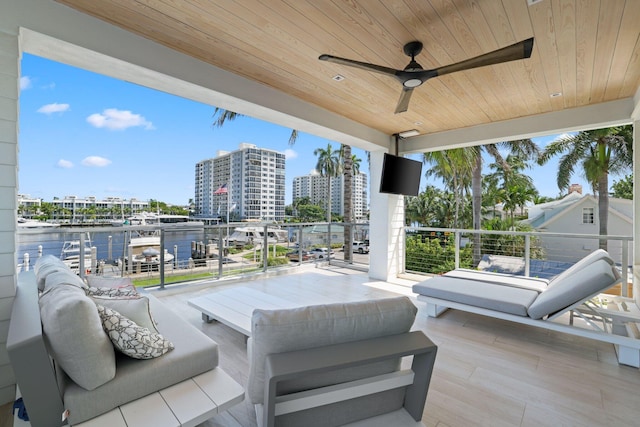 view of patio featuring a balcony, a water view, and ceiling fan