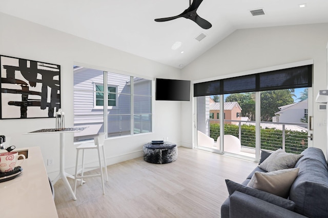 living room with ceiling fan, light wood-type flooring, and vaulted ceiling