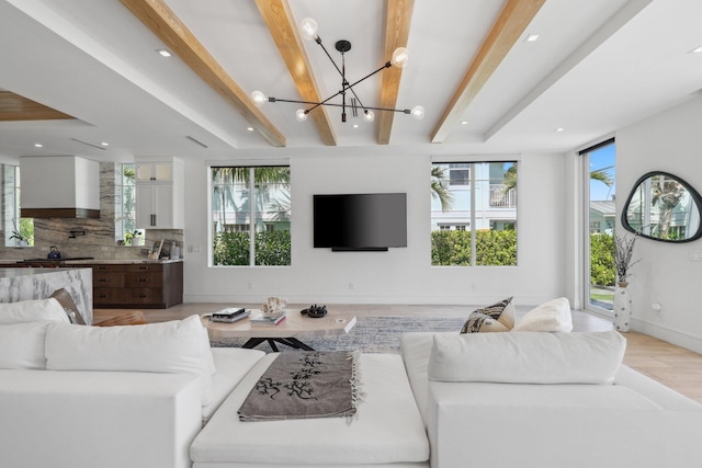 living room featuring beam ceiling, a chandelier, and light wood-type flooring