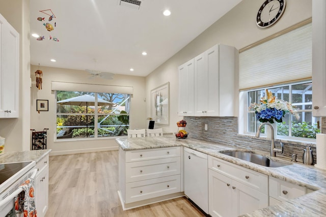 kitchen with white cabinetry, light stone countertops, white appliances, and kitchen peninsula