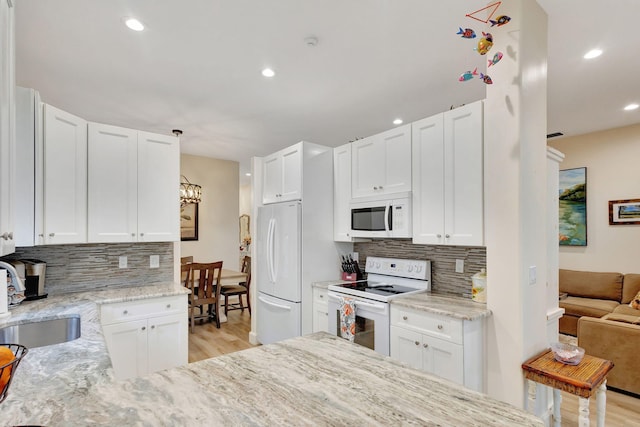 kitchen with white cabinetry, white appliances, and sink