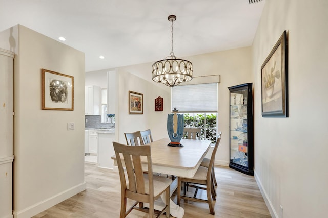 dining space with a chandelier and light hardwood / wood-style floors