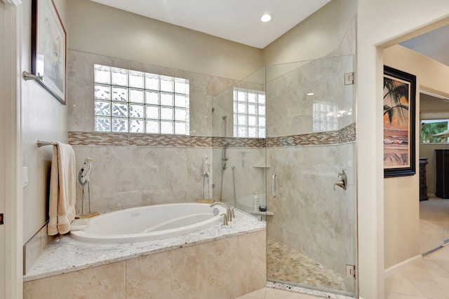 bathroom with separate shower and tub and tile patterned flooring