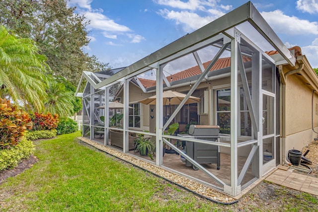 rear view of house with a lawn and a lanai