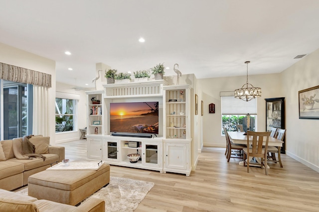 living room featuring a chandelier and light wood-type flooring