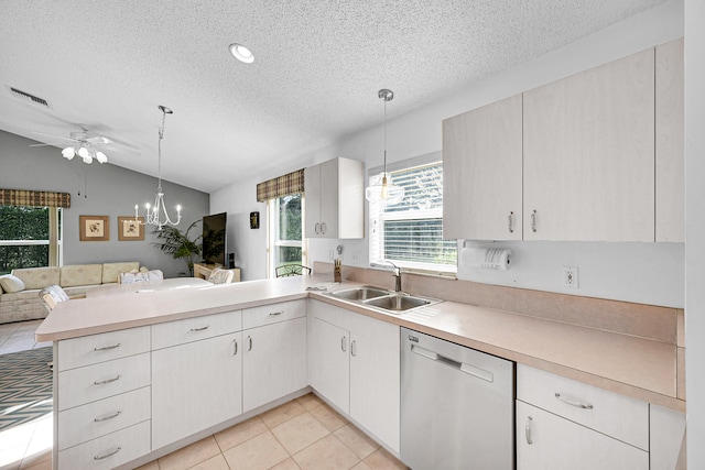 kitchen featuring kitchen peninsula, hanging light fixtures, stainless steel dishwasher, vaulted ceiling, and sink