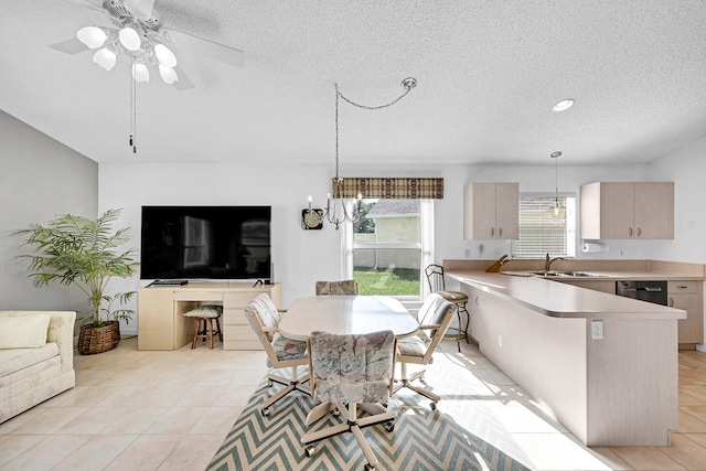 kitchen with decorative light fixtures, sink, light brown cabinetry, and plenty of natural light