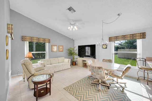 tiled living room with a textured ceiling, lofted ceiling, and ceiling fan with notable chandelier