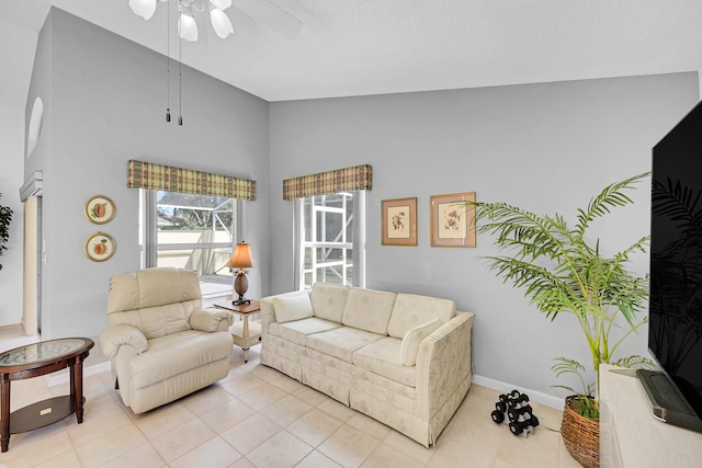 living room with ceiling fan, high vaulted ceiling, and light tile patterned flooring