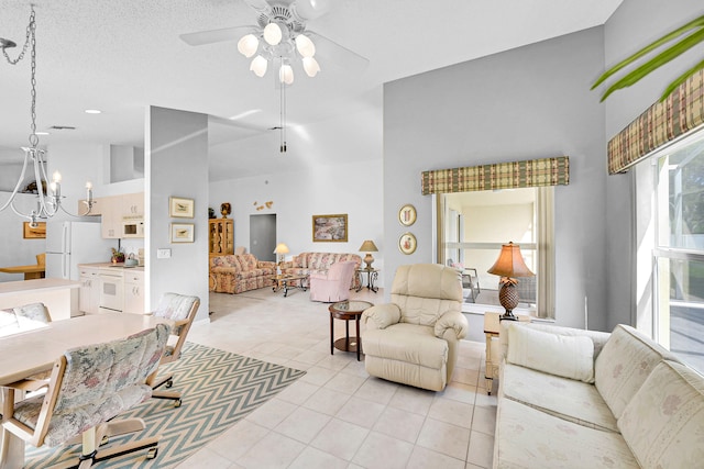 living room with a textured ceiling, light tile patterned flooring, high vaulted ceiling, and ceiling fan with notable chandelier