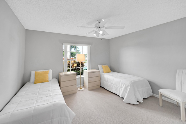 carpeted bedroom with ceiling fan and a textured ceiling