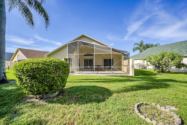 back of house featuring a lawn, a patio area, and glass enclosure