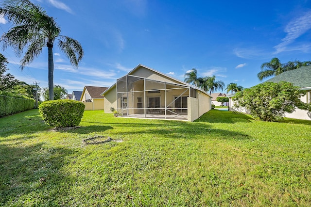 back of property with a lanai and a lawn