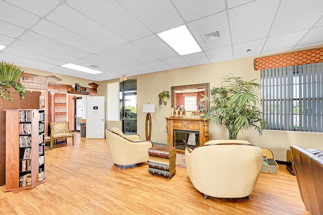 living room with wood-type flooring and a drop ceiling