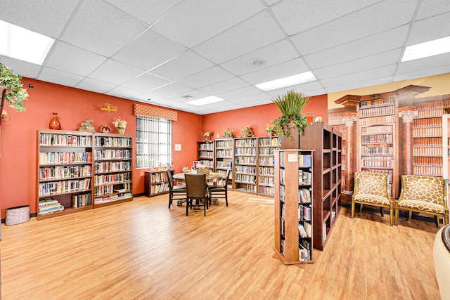 home office with a paneled ceiling and wood-type flooring