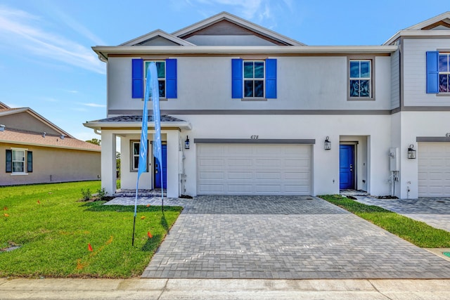 view of front of home with a garage and a front lawn