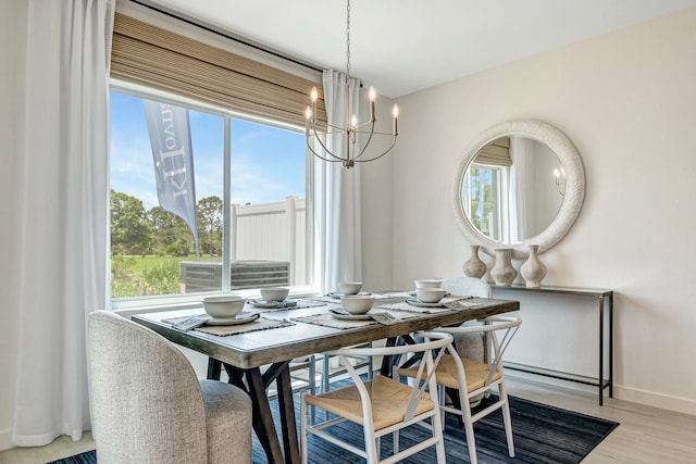 dining room with a notable chandelier and light wood-type flooring